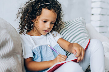 Charming girl writing in notepad