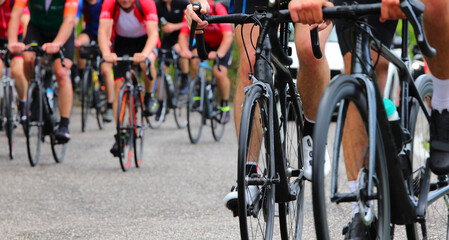 cyclists with racing bikes pedaling during a cycling race on the asphalt road with unrecognizable faces