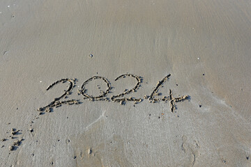 text on the sand with the numbers 2024 ideal as a backdrop for the New Year s Eve party