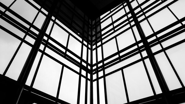 Black and white blurred image of the structure and glass of an office building.