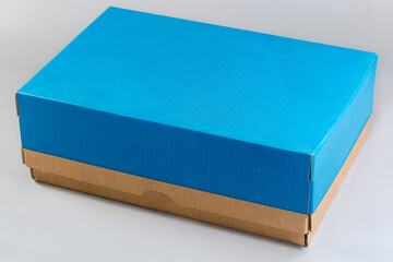 Closed blue kraft cardboard shoebox on a gray background