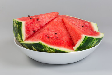 Pieces of the watermelon on dish on gray background
