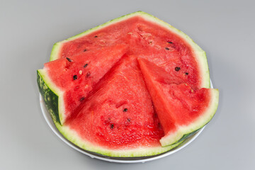 Pieces of the watermelon on dish on gray background