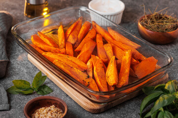 Appetizing sweet potatoes, cut into slices, baked in the oven with spices and butter close-up. Healthy vegan food. Selective focus