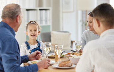 Child, smile and food with family at dining room for Thanksgiving celebration, festive holiday and brunch. Support, love and party with people and dinner for nutrition, grateful and tradition at home