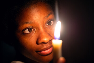 Keep Your Lamps Burning.A young woman holding a candle in the dark