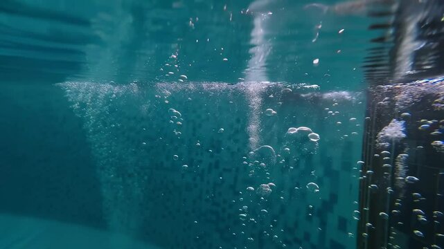 bubbles floating in transparent turquoise clear pool. Multitude of air bubbles rising through clear water