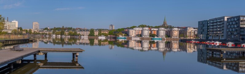 Fototapeta premium Panorama view, the district Hammarby sjöstad, boats, the district Södermalm, piers, boats, commuting ferries and apartment houses, a sunny summer day in Stockholm