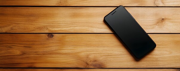 A sleek smartphone rests on a rustic wooden surface, showcasing the contrast between modern technology and natural materials.