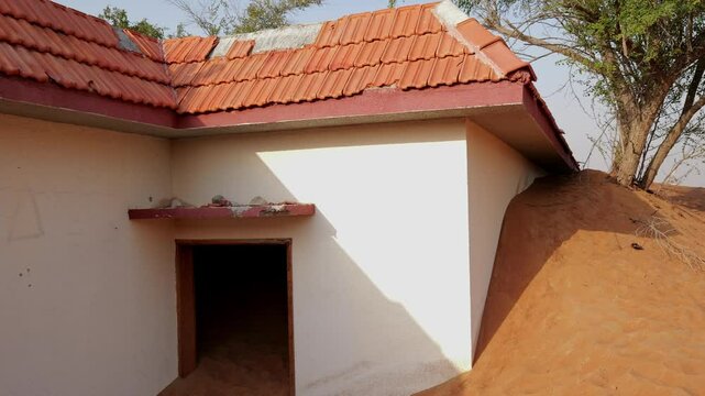 Al Madam ghost town buildings and walls buried in sand dunes in the desert, Sharjah, United Arab Emirates