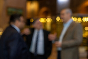 blurred for background. blurred figures of suits men in a event, meeting, conference. business people meet up in success night club or entertainment bar and restaurant, party lifestyle concept