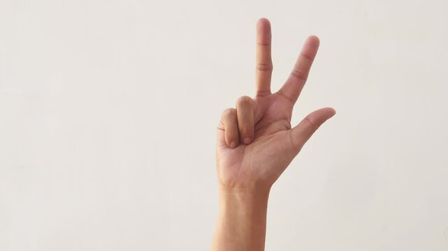 Woman's hands counting the numbers one to ten on a white background. The hand of an adult asian woman shows the numbers one to ten on a white background. 4K slow motion footage.