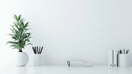A minimalist workspace featuring a plant, stationery, and a clean white background.