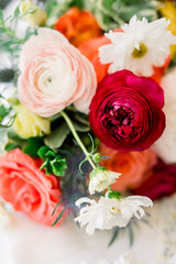 A gorgeous bouquet with red roses, pink and orange flowers and greenery 