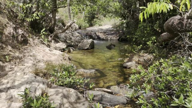 Drone flies backwards over Cachoeira do Pulo in the Parque Nacional da Chapada dos Guimar&atilde;es, Mato Grosso, Brazil
