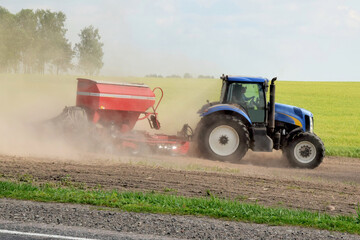 Fototapeta premium A modern tractor produces seeding with a multifunctional seeder
