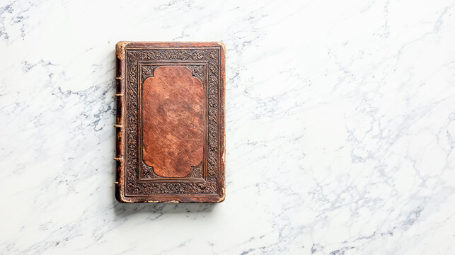 la couverture d'un vieux grimoire pos&eacute; sur un plan de travail en marbre - vu de dessus