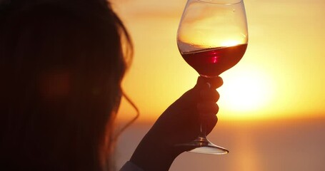 Slow motion silhouette woman tasting wine at the sea sunset