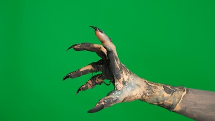 Creepy halloween monster hand in black paint with nails crawling scratching fingers gesture, isolated on chroma key green screen background, workspace mockup.