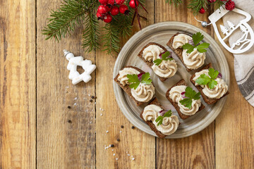 Christmas appetizer New year meal idea. Creative appetizer christmas. Creamy pate sandwiches of herring on a rye bread on the rustic table.