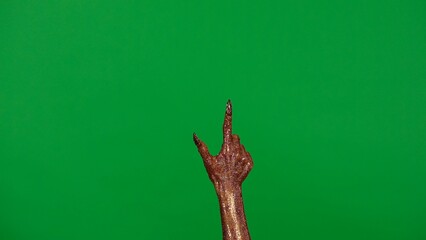 Creepy halloween monster hand in glitter slime with nails pointing finger up, isolated on chroma...