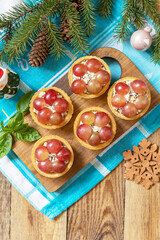 Creative appetizers christmas. Tartlets with chicken and grapes on the festive table on a rustic table.