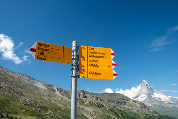 Hiking trail directional signs along the Five Lakes Trail in Zermatt for various hikes. Matterhorn in background. Switzerland