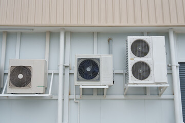 Air compressor or air condenser unit located on support outside building to heat released...