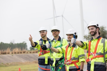 Fototapeta premium Group of male engineer standing together at wind turbines farm, planing maintenance of wind turbines at windmill field farm