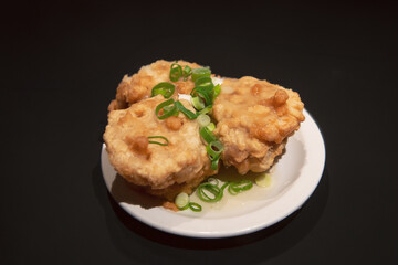 Golden-fried shrimp cakes, a Yum Cha delicacy, served as dim sim meat or prawn patties with scallions on a white plate