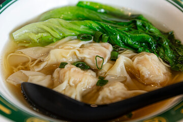 Delicious Hong Kong Wonton Noodle Soup with Fresh Green Bok Choy and Savory Broth, Perfect Comfort Food