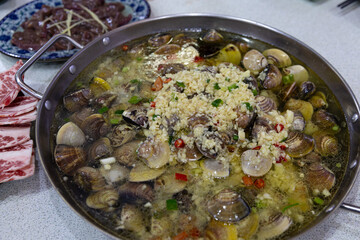 Close-up of Macau-style “Bo Bo Clams/Pipis” hotpot with clams, pipis, vegetables, and broth, served in a large metal pot for traditional hotpot dining