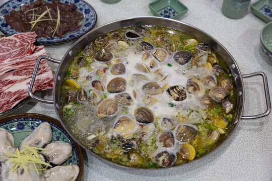 Bo Bo Clams/Pipis hotpot in Macau with clams, pipis, vegetables, and broth, served in a metal pot for a flavorful and traditional dining experience