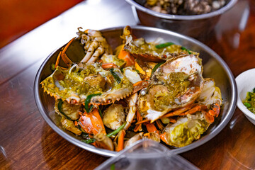 Steamed Cantonese ginger and scallion crab with crab roe, served in a metal dish, highlighting the rich flavors and freshness of the seafood