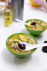 A bowl of Macau-style curry rice vermicelli with chicken, chicken offal, and squid, served with chili paste, in a flavorful and spicy curry broth