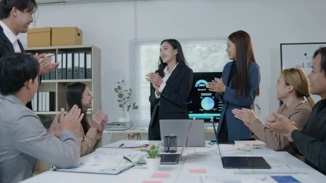 Group of teamwork businesspeople are clapping hands to success and archive on business financial and marketing after working on laptop and paperwork in office