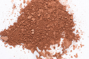 Scattered brown eyeshadow on a white background. Eye shadow texture