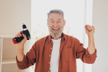 Photo of nice pensioner man fix install shelf drill winning dressed brown garment spend pastime...