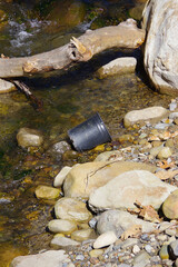 Obraz premium Empty bucket in a forest creek