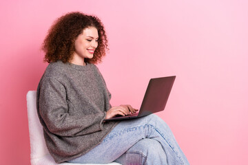 Photo portrait of pretty young girl sit chair netbook wear trendy gray outfit isolated on pink color background