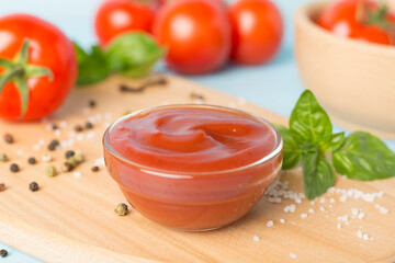 Delicious ketchup with spices and tomatoes on wooden table