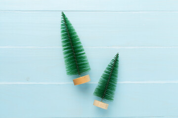 Small christmas tree on wooden background, top view