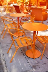 Coffee shop restaurant with orange furniture tables and chairs for guests. cozy street with cafe tables, urban architecture and sights. place for breakfast or dinner for tourists