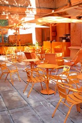 Coffee shop restaurant with orange furniture tables and chairs for guests. cozy street with cafe tables, urban architecture and sights. place for breakfast or dinner for tourists