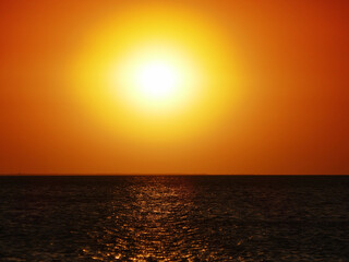 Dull sundown, stuffy air. Sunset over the saltpan lake after a sultry day, dull orange light due to the high humidity
