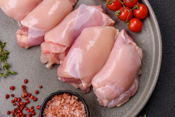 Fresh chicken fillet on a dark concrete table with spices and herbs