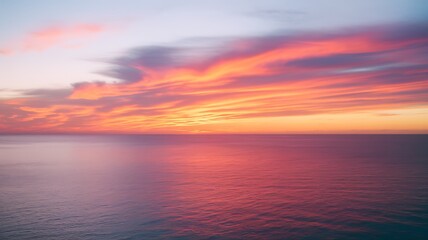 Obraz premium Stunning sunset over ocean with vibrant warm hues painting sky at twilight