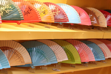 Colorful hand fan souvenirs displayed on shelves