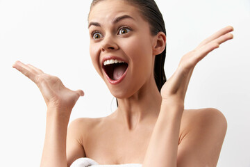 Excited young woman expressing joy and surprise with open hands, white background, natural lighting, cheerful mood, perfect for concepts of happiness and emotional reactions