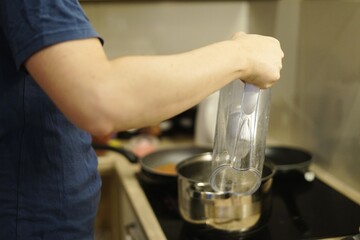 man husband pouring water filter to pot cooking at home family kitchen together help meal dinner